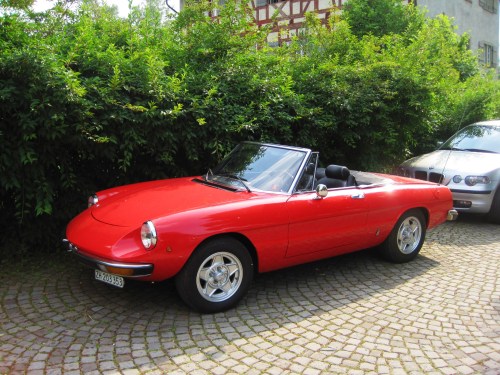 Red. Alfa Romeo. Convertible. Shiny on hundreds years old cobbles. Yes.
